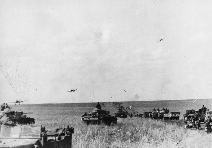 幾架「斯圖卡」飛過德軍裝甲隊列