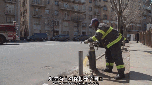 鏡頭裡，一位消防員正在打開消防栓的閥門